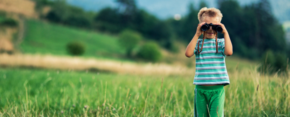 boy with binoculars in field