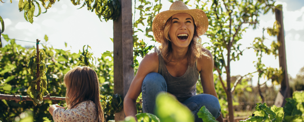 Smiling women with child gardening in a veggie patch